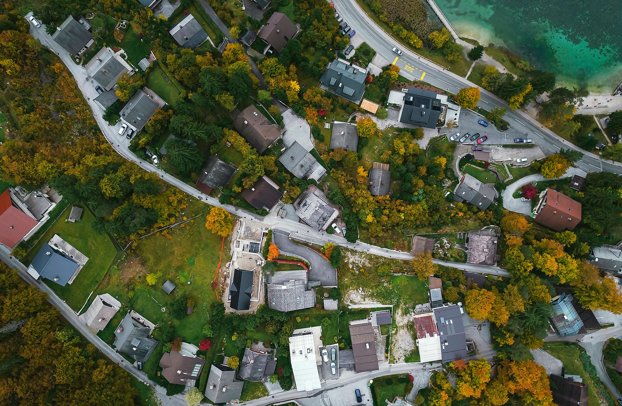 Top-down aerial view of the surrounding neighbourhood, with the turquoise edge of Lake Jasna visible in the upper right.