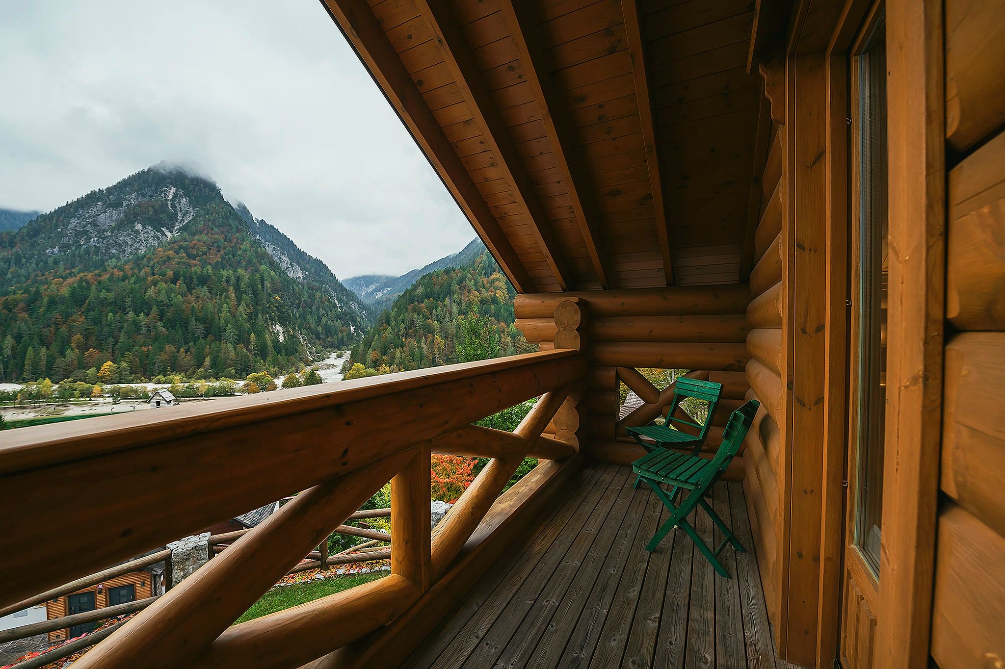 A balcony rail and roofline framing a view of the mountains.
