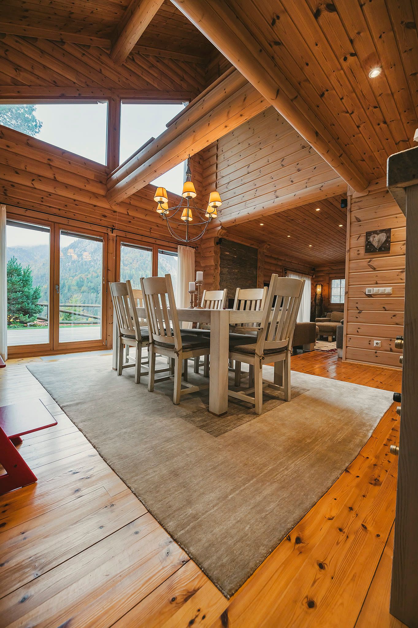 The dining and living area seen from the gallery, framed by a large window wall with mountain light.