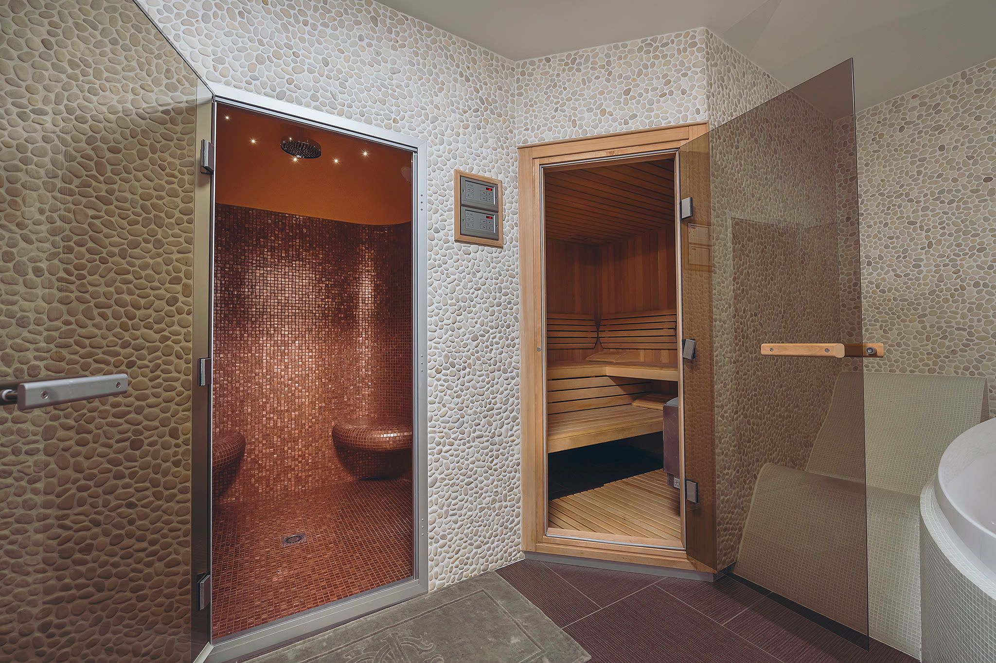Two sauna doors side by side: a glass-fronted steam room and a timber Finnish sauna.